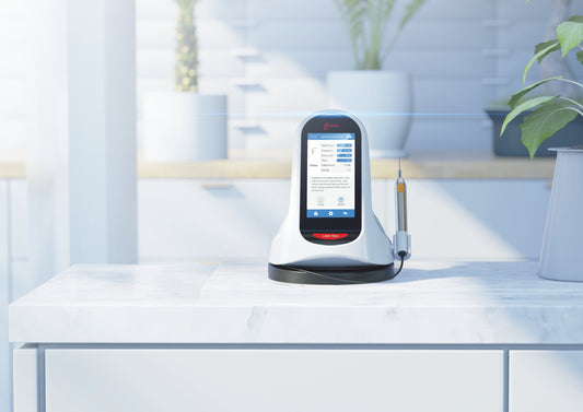 Woodpecker LX16 Plus soft tissue dental laser device placed on a sleek white countertop in a modern dental clinic. The device features a touchscreen interface displaying treatment options and settings. Its ergonomic design includes a laser handpiece positioned neatly in a docking station. Ideal for soft tissue procedures like gingivectomy, frenectomy, and periodontal therapy, ensuring precise, pain-free, and efficient dental treatments.